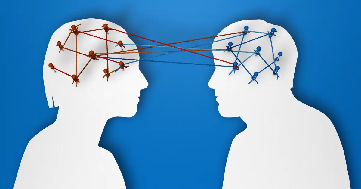 Concept illustration showing two people exchanging knowledge through interlinked neural networks,