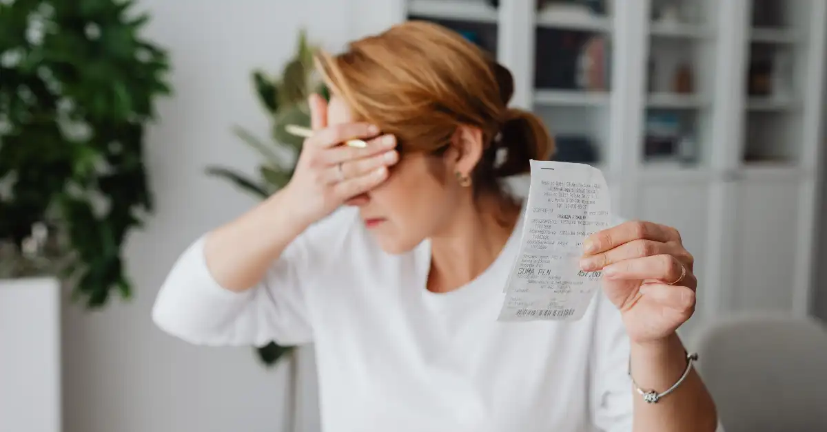 retail-therapy-or-red-flag. Person covering face with a piece of paper after shopping, symbolizing emotional spending and its hidden impact.